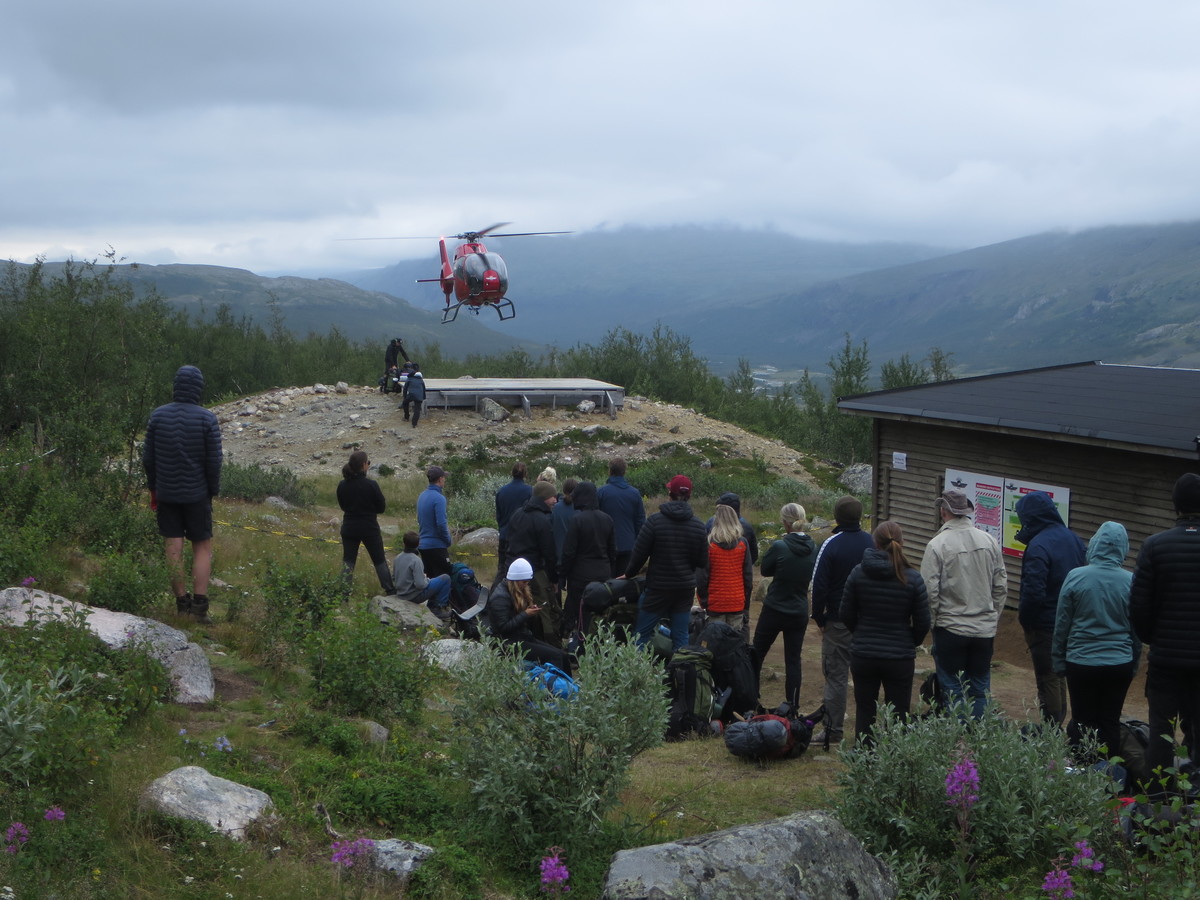 Množica osvajalcev najvišjega vrha Švedske čaka na prevoz s helikopterjem v dolino
